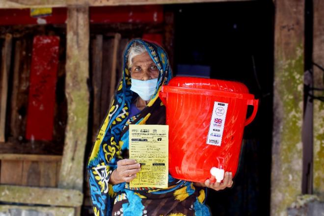 A cyclone victim receives relief materials
