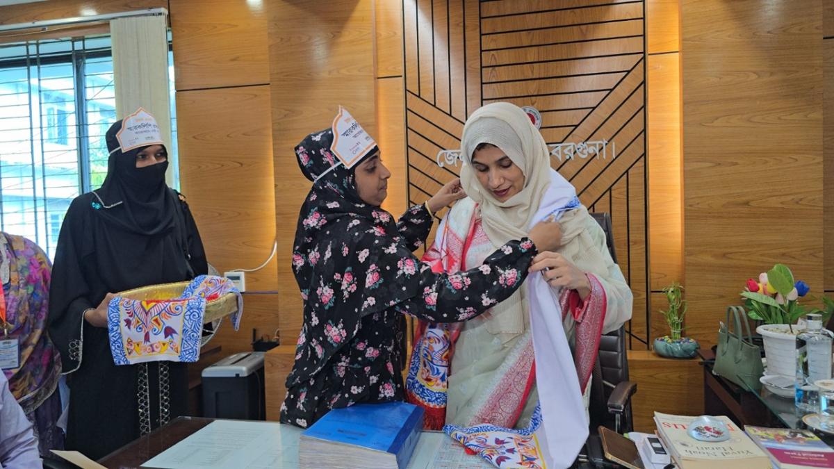Women draping a ceremonial scarf (uttariya) around Barguna Deputy Commissioner Ms. Taslima Akter